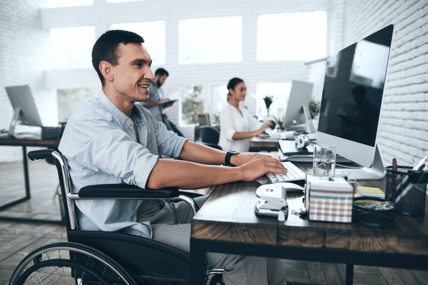 Disabled person in the wheelchair works in the office