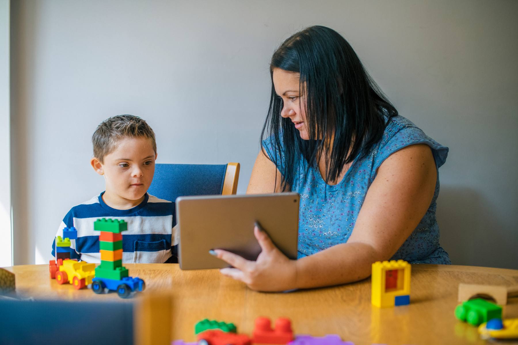 Mother teaching son from a tablet